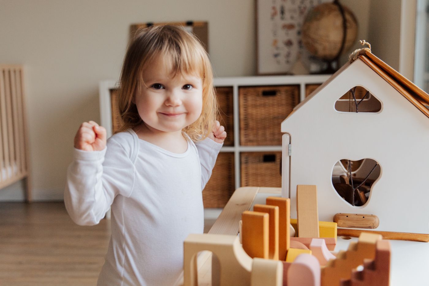 Toddler playing with a wooden house and blocks in a calm room