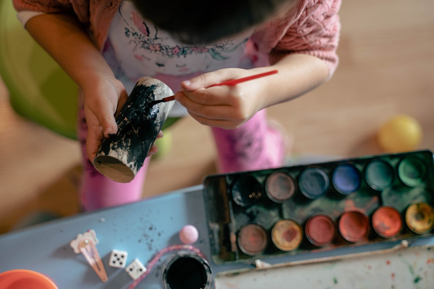 Child's hands painting a cardboard model